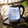Bouilloire electrique verre lumineuse avec éclairage bleu et eau bouillante sur un plateau en bois sombre style zen