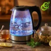 Bouilloire electrique verre lumineuse avec eau bouillante et éclairage bleu intense sur son socle en acier inoxydable