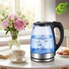 Bouilloire électrique verre lumineuse avec eau bouillante et bulles d'air, posée sur table près de fleurs roses