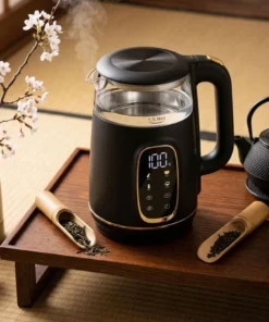 Bouilloire thermostat ecran tactile noire en verre et métal affichant 100 degrés sur un plateau en bois avec du thé noir