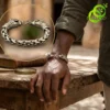 Homme portant un bracelet dragon en argent tibétain tressé avec fermoir tête de créature mythique sur un poignet brun