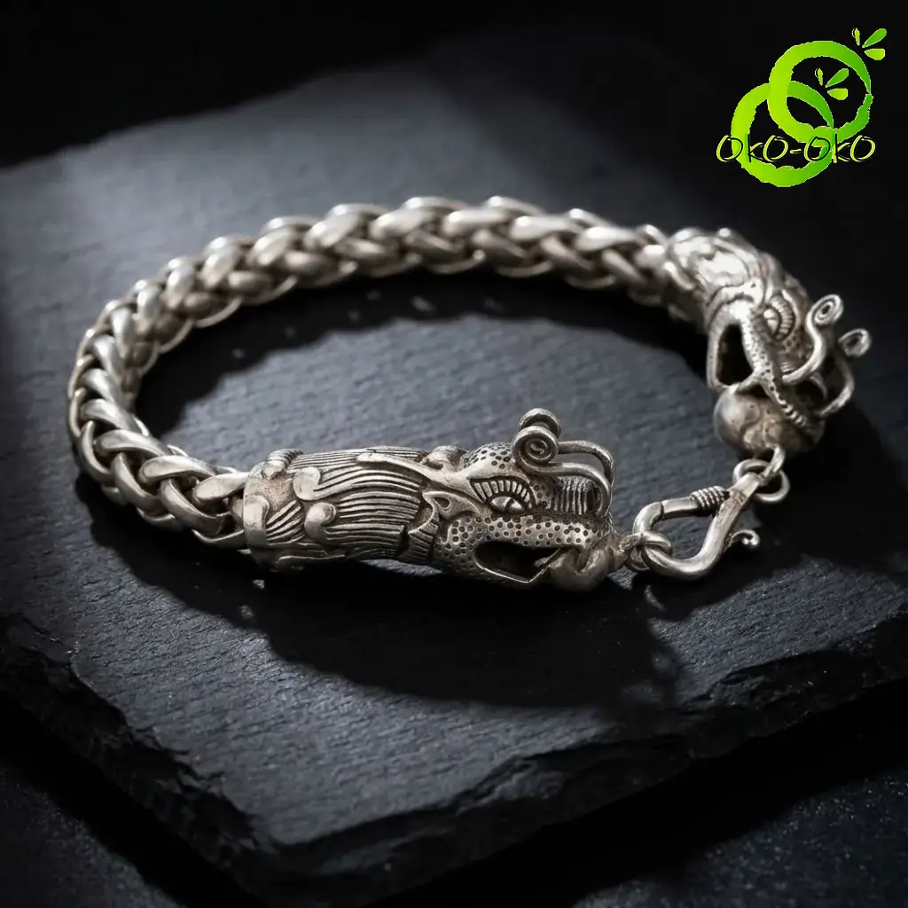 Bracelet dragon en argent tibétain | OkO-OKO™ Gros plan sur la maille tressée d'un bracelet dragon en argent tibétain posé sur une pierre noire texturée