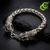 Bracelet dragon en argent tibétain | OkO-OKO™ Gros plan sur la tête sculptée d'un bracelet dragon en argent tibétain posé sur une pierre noire texturée sombre