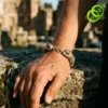 Bracelet dragon en argent tibétain | OkO-OKO™ Gros plan sur un bracelet dragon en argent tibétain porté au poignet, posé sur une pierre ancienne au soleil