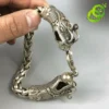 Bracelet dragon en argent tibétain | OkO-OKO™ Gros plan sur la tête sculptée d'un bracelet dragon en argent tibétain avec maillons tressés et détails ciselés fins