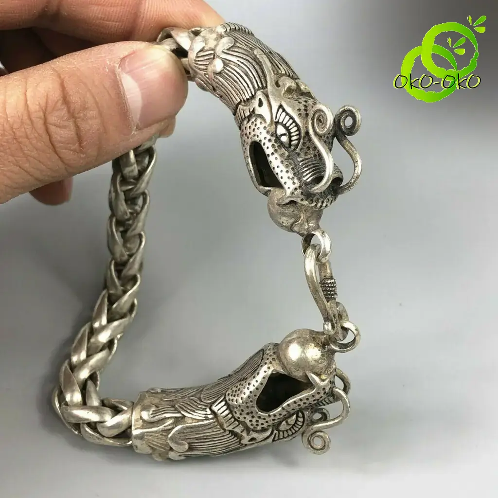 Bracelet dragon en argent tibétain | OkO-OKO™ Gros plan sur la tête sculptée d'un bracelet dragon en argent tibétain avec maillons tressés et détails ciselés fins