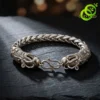 Bracelet dragon en argent tibétain | OkO-OKO™ Gros plan sur le fermoir crochet d'un bracelet dragon en argent tibétain au design tressé posé sur roche noire sombre