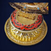 Roue du Dharma dorée ou Dharmachakra aux détails précieux et dorés | OkO-OKO™ Close-up of the ornate gold base of a roue dharma doree dharmachakra featuring red enamel patterns and intricate carvings