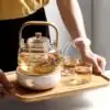 Théières en Verre <br> Avec filtre Transparent. | OkO-OKO™ Théière en Verre avec Filtre posé sur un plateau avec chauffe-théière | OkO-OkO