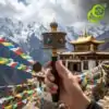 Molinillo de oración tibetano con mantras grabados | OkO-OKO™ Mano sosteniendo un moulin de oración tibetano de latón con mantras y símbolos grabados frente a picos nevados del Himalaya y un templo dorado