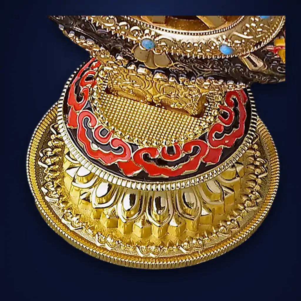 Roue du Dharma dorée ou Dharmachakra aux détails précieux et dorés | OkO-OKO™ Close-up of the ornate gold base of a roue dharma doree dharmachakra featuring red enamel patterns and intricate carvings