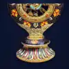 Roue du Dharma dorée ou Dharmachakra aux détails précieux et dorés | OkO-OKO™ Close-up of the ornate base of this roue dharma doree dharmachakra with colorful floral patterns and golden engravings