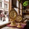 Roue du Dharma dorée ou Dharmachakra aux détails précieux et dorés | OkO-OKO™ Close-up of two ornate roue dharma doree dharmachakra sculptures with turquoise inlays on a rustic wooden table
