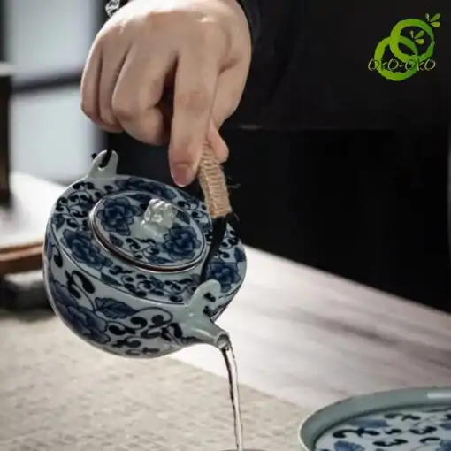 Blue and white porcelain tea set with a traditional lotus pattern | OkO-OKO™ A teapot from a blue-and-white porcelain set featuring a traditional lotus pattern, served in a tranquil setting