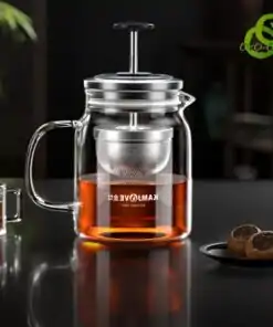 théière en verre transparent avec filtre métallique descendable et remontable, remplie d'une infusion ambrée, sur une surface noire réfléchissante