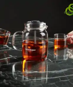 théière verre filtre transparente avec système de filtration ascendant descendant sur table noire marbrée